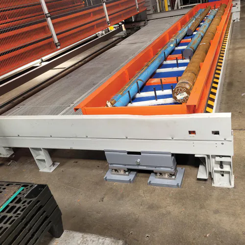 Plate-forme de pesage rehaussée installée en atelier industriel, charges longues posées sur les rouleaux